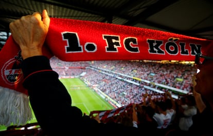 Un aficionado del Colonia exhibe una bufanda de su equipo durante un partido de la Bundesliga.