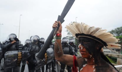 Un indígena participa en una protesta en Río rodeado de policías.