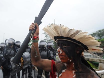 Un indígena participa en una protesta en Río rodeado de policías.