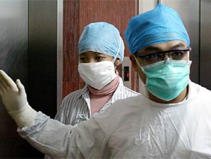 A la izquierda, la nueva afectada de SARS al entrar en el hospital del Pueblo número 8 de Guangzhou.