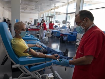 Un miembro del personal sanitario le extrae sangre a un hombre en el Centro de Transfusión de la Comunidad de Madrid.