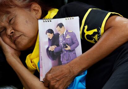 Una mujer tailandesa duerme frente al Gran Palacio Real de Bangkok, junto a un retrato del rey Bhumibol. Se estima que entre 250.000 y 300.000 personas asistirán a los rituales funerarios en la capital, donde monjes budistas y sacerdotes hindúes velarán este miércoles el cuerpo del monarca en el Palacio Real.