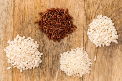 Four different kinds of rice on a wooden board: Carnaroli rice (Italy), Camargue red rice (France), Basmati long grain rice (India) and Bomba rice (Spain)