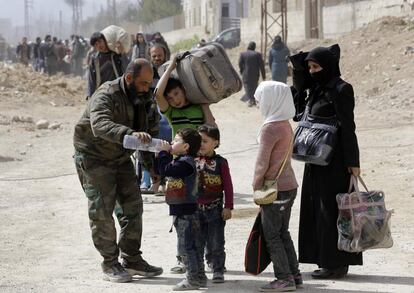 La cadena estatal siria de noticas Al Akhbarie ha retransmitido imgenes de civiles caminando o a bordo de vehculos privados escoltados por las tropas regulares que, una vez llegados al paso terrestre de Wafidin, han sido atendidos por la Media Luna Roja Siria. En la fotografa, un miembro de las fuerzas del gobierno sirio da agua a un ni?o sirio, el 15 de marzo de 2018.