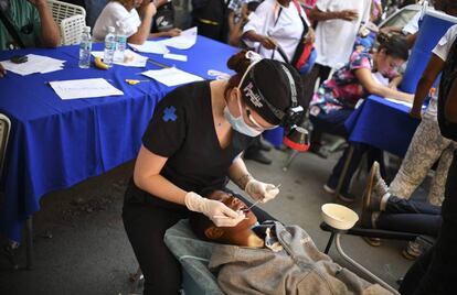 Un voluntario de 'coalición por la ayuda y la libertad' atiende a un joven en Caracas 