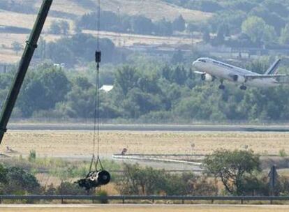 Una grúa recogía ayer parte de uno de los motores del avión siniestrado el miércoles pasado.