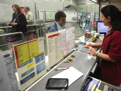 Una taquillera vendiendo un billete a una viajera en la estación de Sevilla