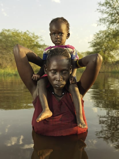 Bol Nual, de 26 años, con
su hija Pouch Deng, de 2,
de camino al centro de
salud local para que
revisen a la pequeña,
que tiene fiebre.