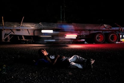 Un hombre, parte de la segunda caravana de migrantes centroamericanos, descansa al lado de la autopista hacia Ciudad Tecun Uman (Guatemala), el 16 de enero de 2019. En un gesto histórico, el Gobierno mexicano de López Obrador ofreció permisos de residencia por razones humanitarias a todos los migrantes centroamericanos en la frontera este jueves. Más de 500 migrantes hondureños forman parte de esta caravana que inició en Honduras el 14 de enero con la idea de cruzar Guatemala y llegar a Estados Unidos.