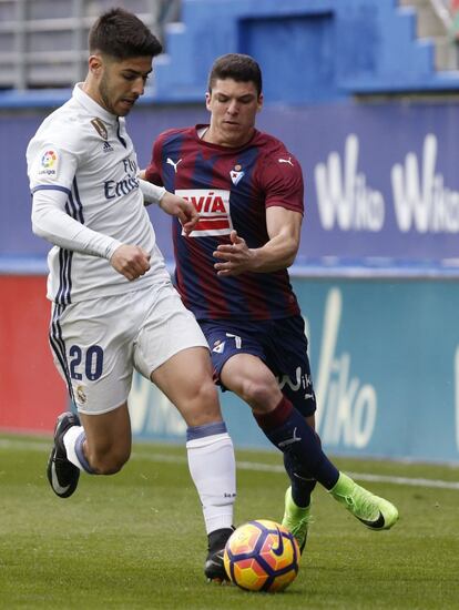 El defensa del Eibar, Ander Capa, lucha un balón con el centrocampista Marco Asensio.