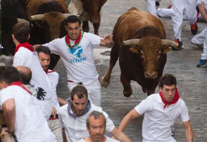 Mozos ante los toros de Jandilla, durante el quinto encierro de los sanfermines 2016.