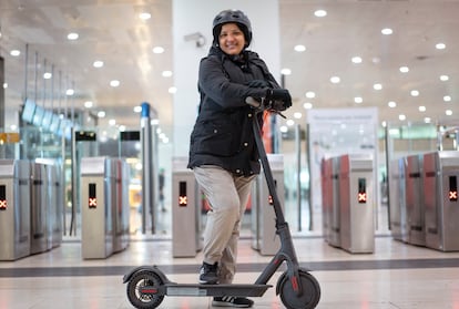 Rita Rosado y su patinete, que cambiará por la moto a partir del 1 de febrero, delante de las puertas de salida de Rodalies de la estación de Sants (Barcelona).