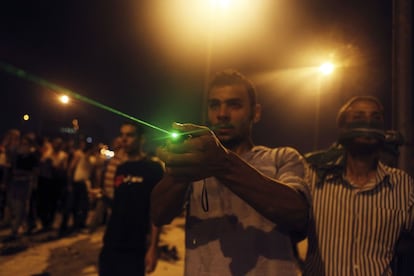 Un partidario del expresidente Mohamed Morsi utiliza un laser para señalar a la policía egipcia durante los enfrentamientos en la plaza de Damsés, en el centro de El Cairo, 15 de julio de 2013. 