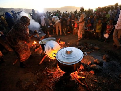 Refugiados etíopes que huyen de la guerra en Tigray esperan a recibir comida en el campo de refugiados sudanés de Um-Rakoba, cerca de la frontera entre ambos países, el pasado lunes.