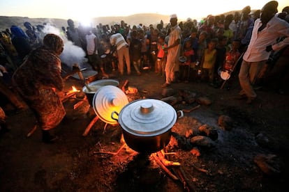 Refugiados etíopes que huyen de la guerra en Tigray esperan a recibir comida en el campo de refugiados sudanés de Um-Rakoba, cerca de la frontera entre ambos países, el pasado lunes.