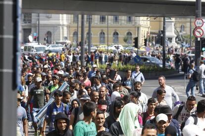 Decenas de migrants encallats en Budapest marxen a peu cap a Austria.