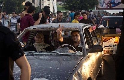 Un palestino muestra la señal de victoria mientras maneja su coche entre las multitudes. Egipto ha anunciado que el alto el fuego incluye la apertura inmediata de la frontera con Israel, para dejar pasar ayuda y suministros de reconstrucción.