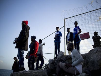 Varios jóvenes tras la valla que separa Ceuta de Marruecos donde cayó herido el chico de 16 años. 