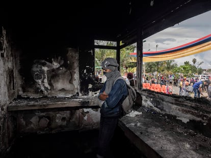 Un joven monta guardia en el interior de una estación de Policía que fue quemada por los manifestantes en Puerto Resistencia, Cali, este miércoles.