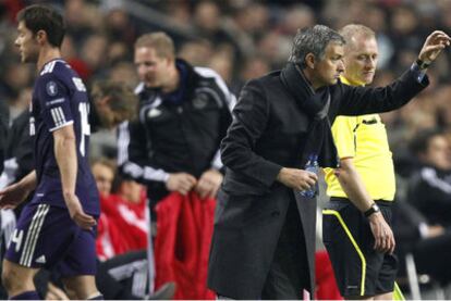 Xabi Alonso se retira, expulsado, mientras José Mourinho sigue dando instrucciones a sus jugadores.