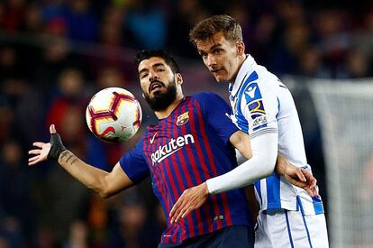 El delantero del FC Barcelona Luis Suárez pelea un balón con Diego Llorente, de la Real Sociedad, durante el partido de Liga en Primera División en el Nou Camp.