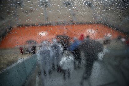 Gotas de lluvia caen por un cristal de la cancha central del Abierto de Roland Garros de París.