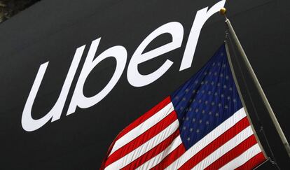 El logo de Uber junto a una bandera de Estados Unidos frente a la Bolsa de Nueva York.