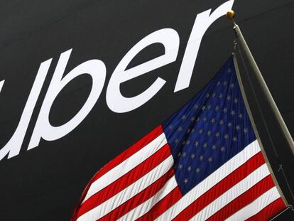 El logo de Uber junto a una bandera de Estados Unidos frente a la Bolsa de Nueva York. 