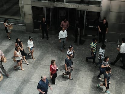 Várias pessoas passam em frente à sede do banco Goldman Sachs, em Nova York.