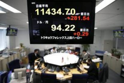 Un monitor muestra el índice Nikkei (arriba) y el tipo de cambio del yen frente al dólar estadounidense en una oficina de corretaje en Tokio, Japón.