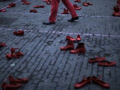 Um homem caminha entre sapatos femininos em um protesto contra a violência machista em Barcelona (Espanha), na segunda-feira.