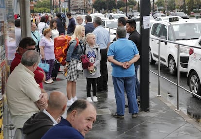 un grupo de viajeros junto a la parada del AVE de Valencia, con los taxistas parados. 
