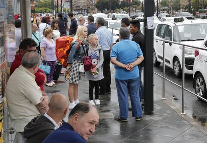 un grupo de viajeros junto a la parada del AVE de Valencia, con los taxistas parados.