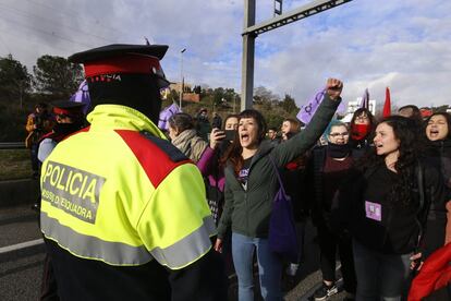 Grup de manifestants davant d'un agent dels Mossos d'Esquadra a la C-58.