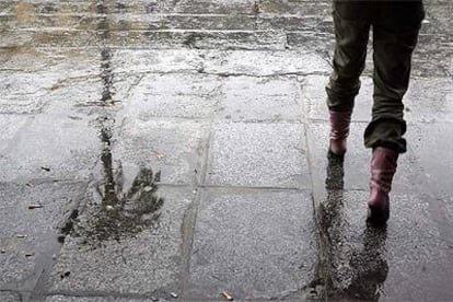 Una vecina de Sevilla paseaba ayer bajo la lluvia.