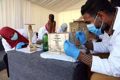 Arqueólogos egipcios estudiando el material descubierto en Saqqara.