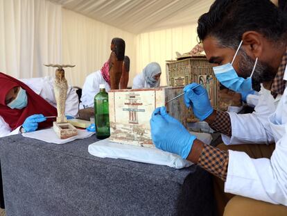 Arqueólogos egipcios estudiando el material descubierto en Saqqara.