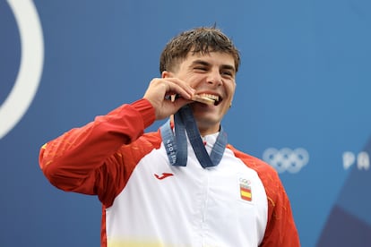 El español Pau Echaniz muerde su medalla de bronce en el podium.