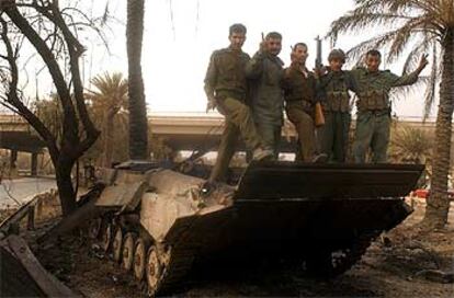 Soldados iraquíes posan en un vehículo blindado destruido en una batalla librada en Bagdad.