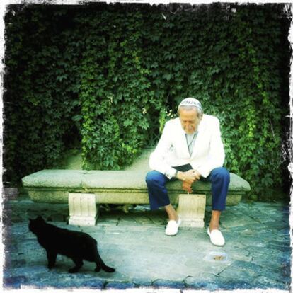 El diseñador Elio Berhanyer, un enamorado de los felinos, junto a un gato negro en la entrada del Jardín Botánico.