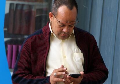 Un hombre consulta su tel&eacute;fono movil. 