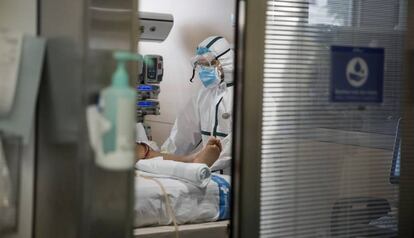 Un sanitario atiende a un paciente de la UCI del Hospital Vall d'Hebron de Barcelona.