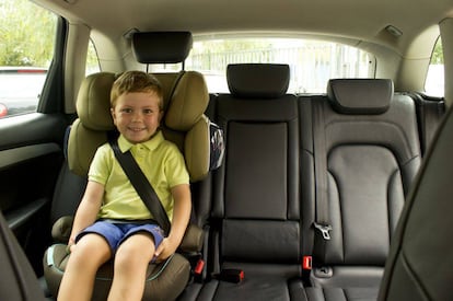 Un niño sentado en su silla infantil, dentro del coche.