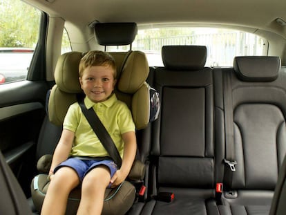 Un niño sentado en su silla infantil, dentro del coche.