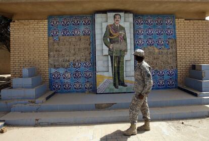 Un soldado estadounidense pasa delante de un mural consagrado a Sadam Husein, en la Base Victoria, en una imagen datada en abril de 2011.