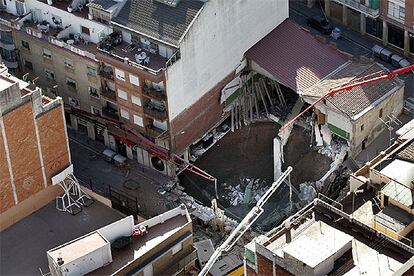 A pesar del inmenso socavón, no hubo heridos. Tanto el garaje como el edificio colindante en el que vivían 25 personas llevaban desalojados dos días, desde que se produjo el desprendimiento del subsuelo.