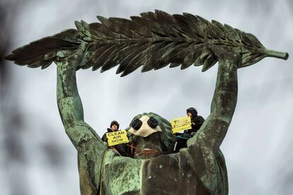 Dos activistas de Greenpeace protestan este martes contra la contaminación ambiental desde lo alto de la estatua de la Libertad de Budapest (Hungría).