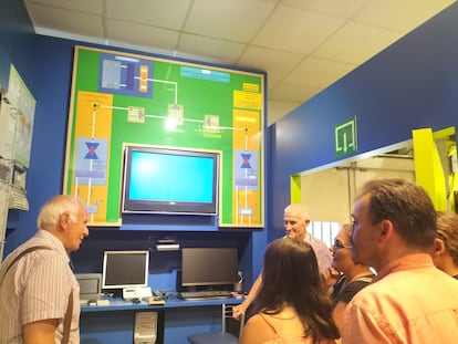 Ernesto López (izquierda) y José Luis Sotelo, respectivamente secretario y vicepresidente de la Asociación del Museo Didáctico de las Telecomunicaciones, enseñan el Muditel a una familia coruñesa.