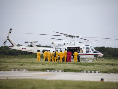 Trabajadores de Pemex abordan un helicóptero.