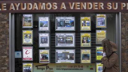 Una mujer pasa junto a una inmobiliaria en Madrid.